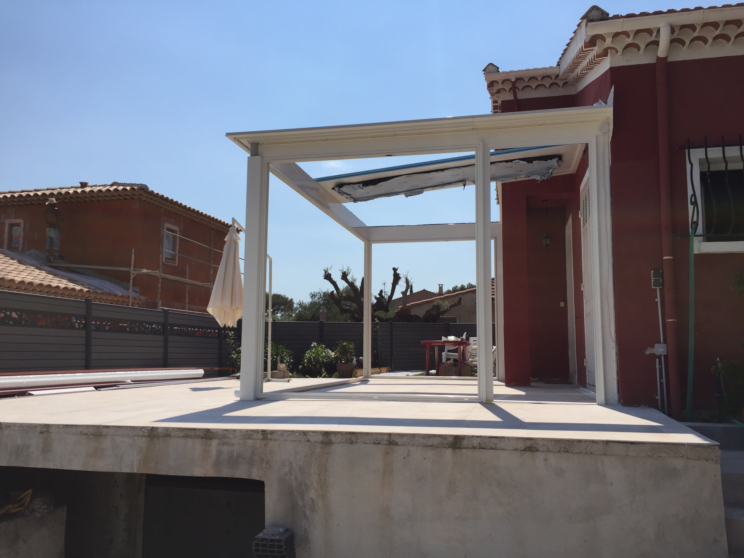 Installation de la structure en aluminium blanc pour une véranda modèle Bacara à La Valette-du-Var, en cours de montage sur une terrasse.